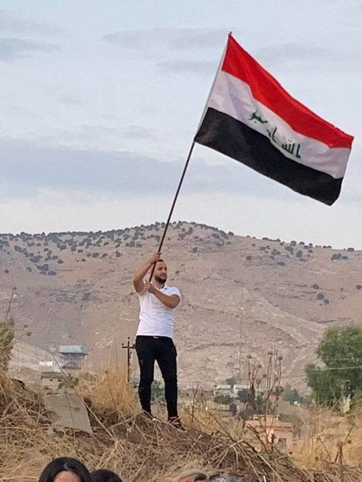 مسيحي يرفع العلم العراقي
