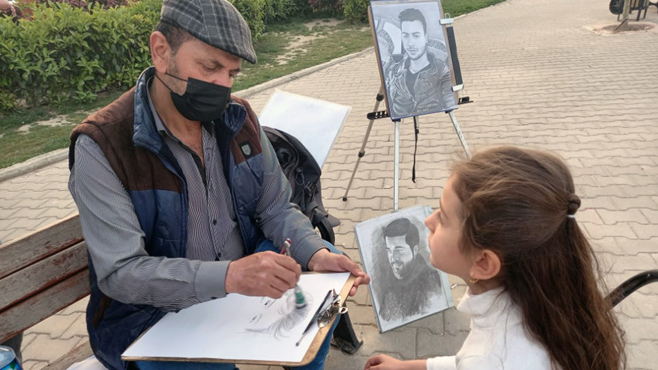 Emir, göçmen çocukları resimlerini çizerek mutlu ediyor