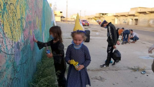 الاطفال العائدون يرسمون الجدران فى ناحية القحطانية
