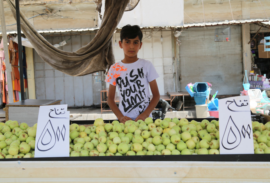 Adım Ercan Adil, 12 yaşındayım. Beşinci sınıfta öğrenciyim. Tatilde veya başka zamanlarda babama yardım ediyorum. Habat Köprüsü'nde sebze ve meyve satıyorum. Günde 5 bin dinar kazanıyorum.